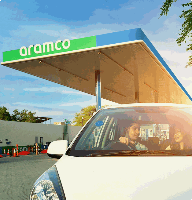 White car under Aramco station canopy